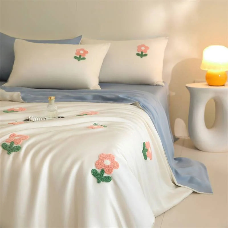Tufted Doodle Flower Cooling Tencel Bedding Set in White & Sky Blue, styled on a bed with a modern lamp. - RoomDen
