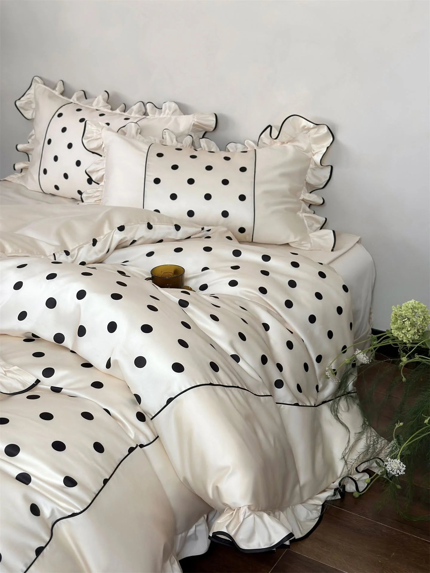 Detail shot of the duvet cover and pillows of the Creamy White & Black Polka Dot set, highlighting the Tencel fabric - RoomDen.