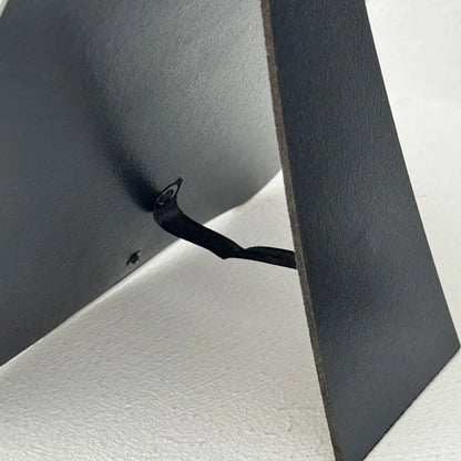 Detailed view of the black easel stand mechanism on the back of the irregular mirror - RoomDen