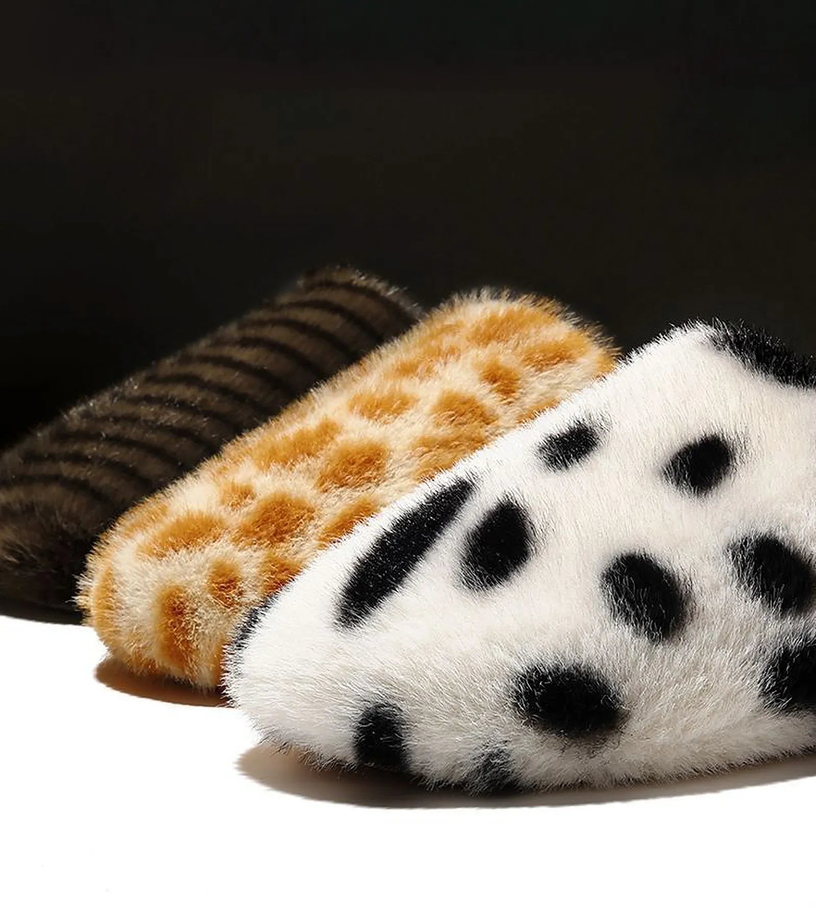 Three variants of animal print slippers lined up: Brown Stripes, Beige Spots, White Spots