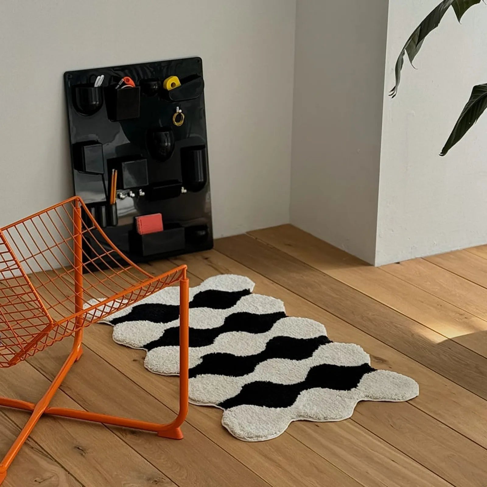 High contrast wavy black and white rug on wooden floor with wall organizer - RoomDen