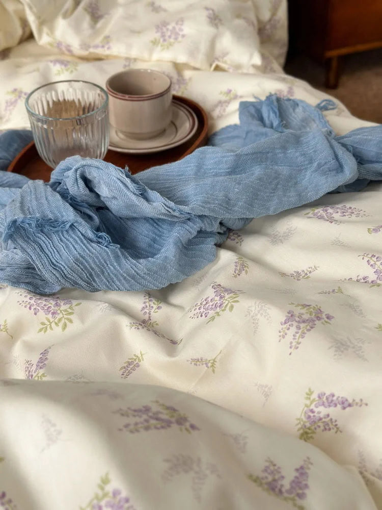 Detail shot of the delicate purple wisteria floral pattern on the soft washed cotton fabric - RoomDen.