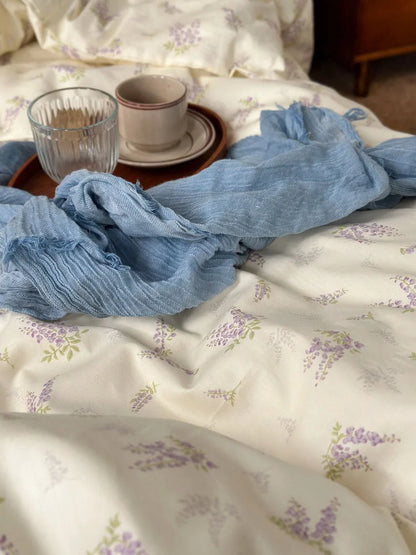 Detail shot of the delicate purple wisteria floral pattern on the soft washed cotton fabric - RoomDen.