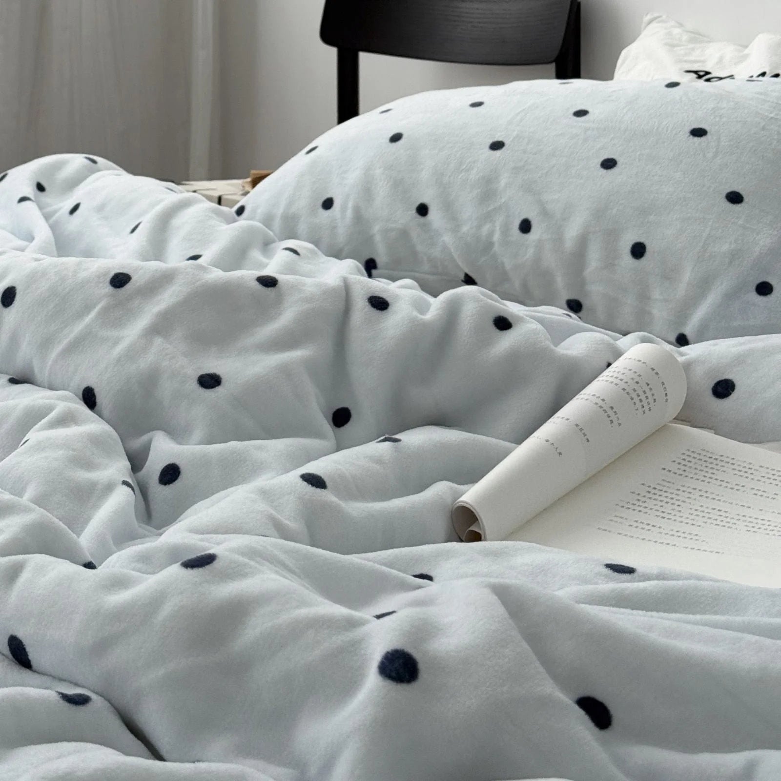 Softly lit view of the rumpled Light Blue Polka Dot Flannel Fleece Bedding, conveying a sense of comfort.