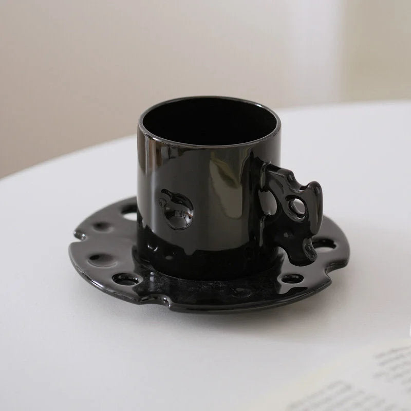 The Cheese Ceramic Mug & Saucer Set in Glossy Black on a clean white surface. - RoomDen
