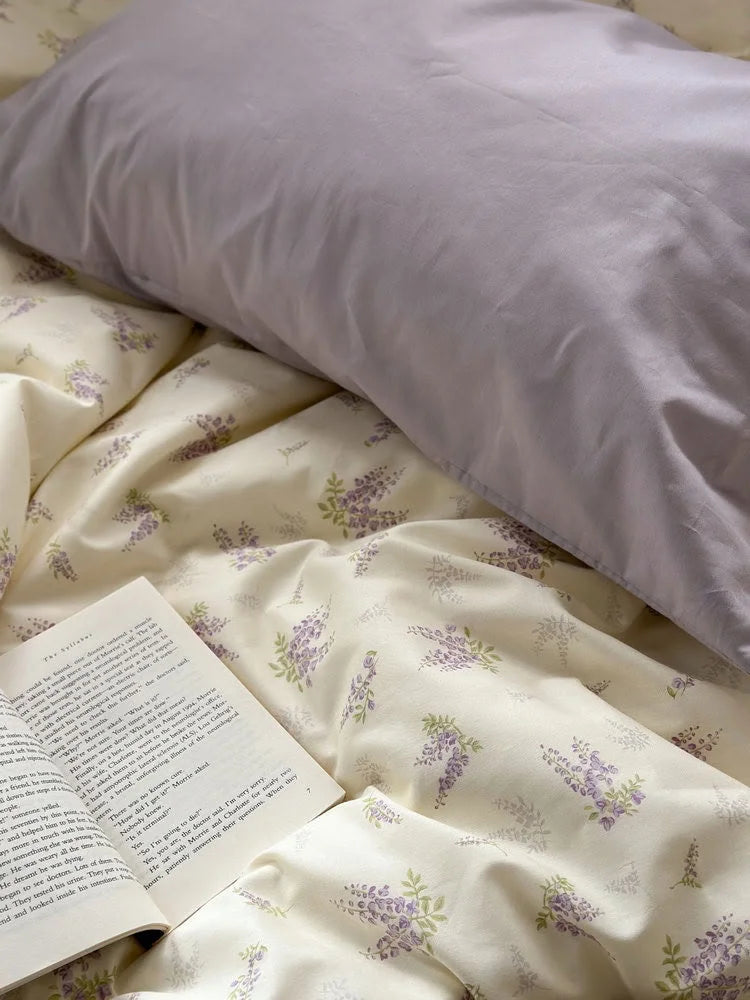 A close-up showing the texture of the solid lavender pillowcase against the wisteria floral duvet cover - RoomDen.