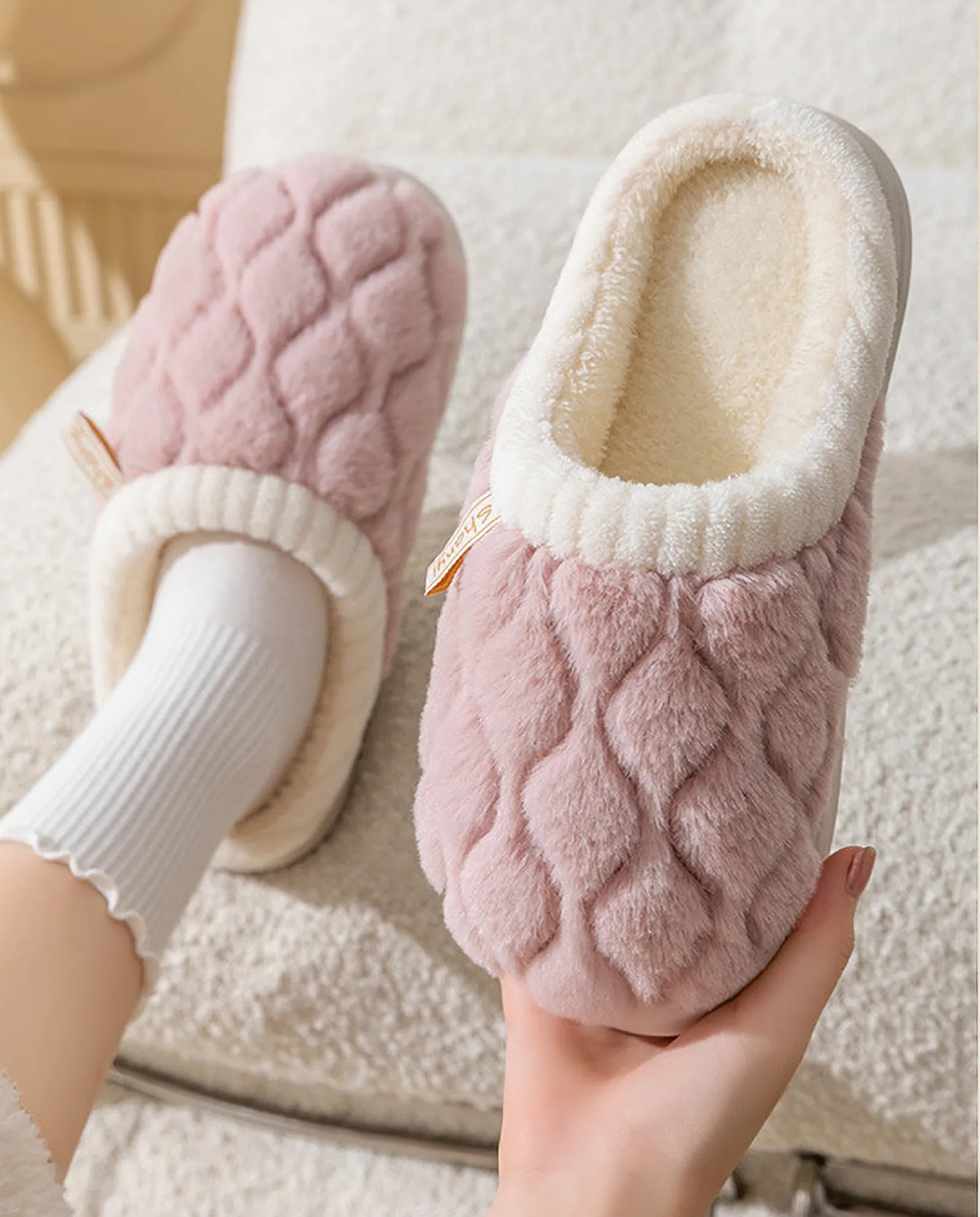 Close up of Dusty Pink plush slipper held in hand showing diamond texture - RoomDen