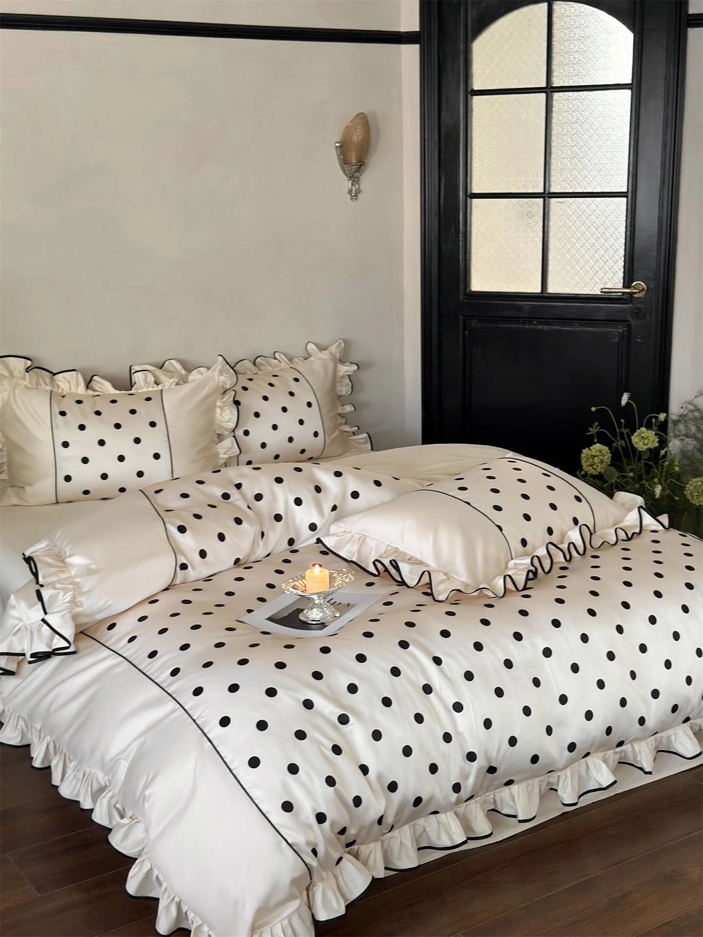 Lifestyle shot of the Creamy White & Black Polka Dot Bedding Set with a candle on a tray - RoomDen.