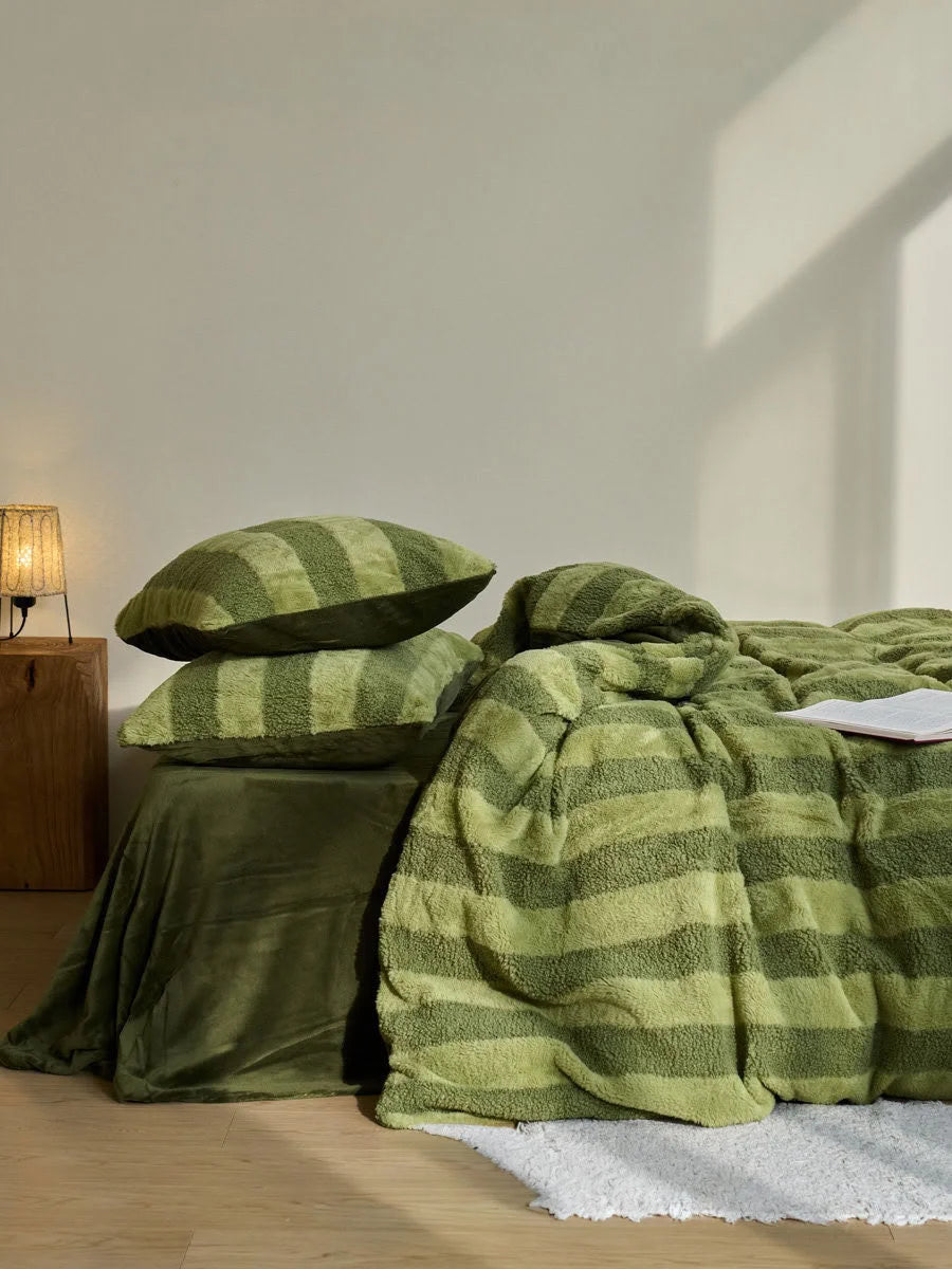 Green plush bedding set styled in a warm cozy bedroom environment - RoomDen