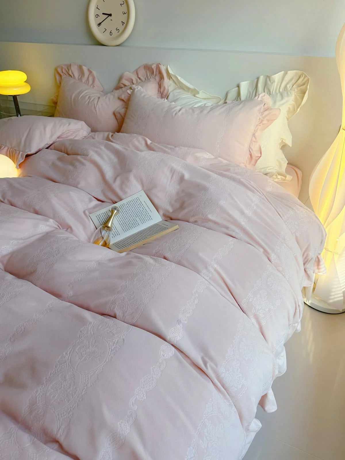Angled shot of the Blush Pink bedding with an open book, highlighting its dreamy aesthetic. - RoomDen