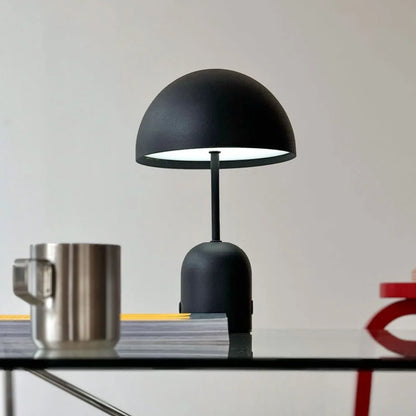 Close-up of the Matte Black mushroom lamp turned on, casting a warm glow - RoomDen