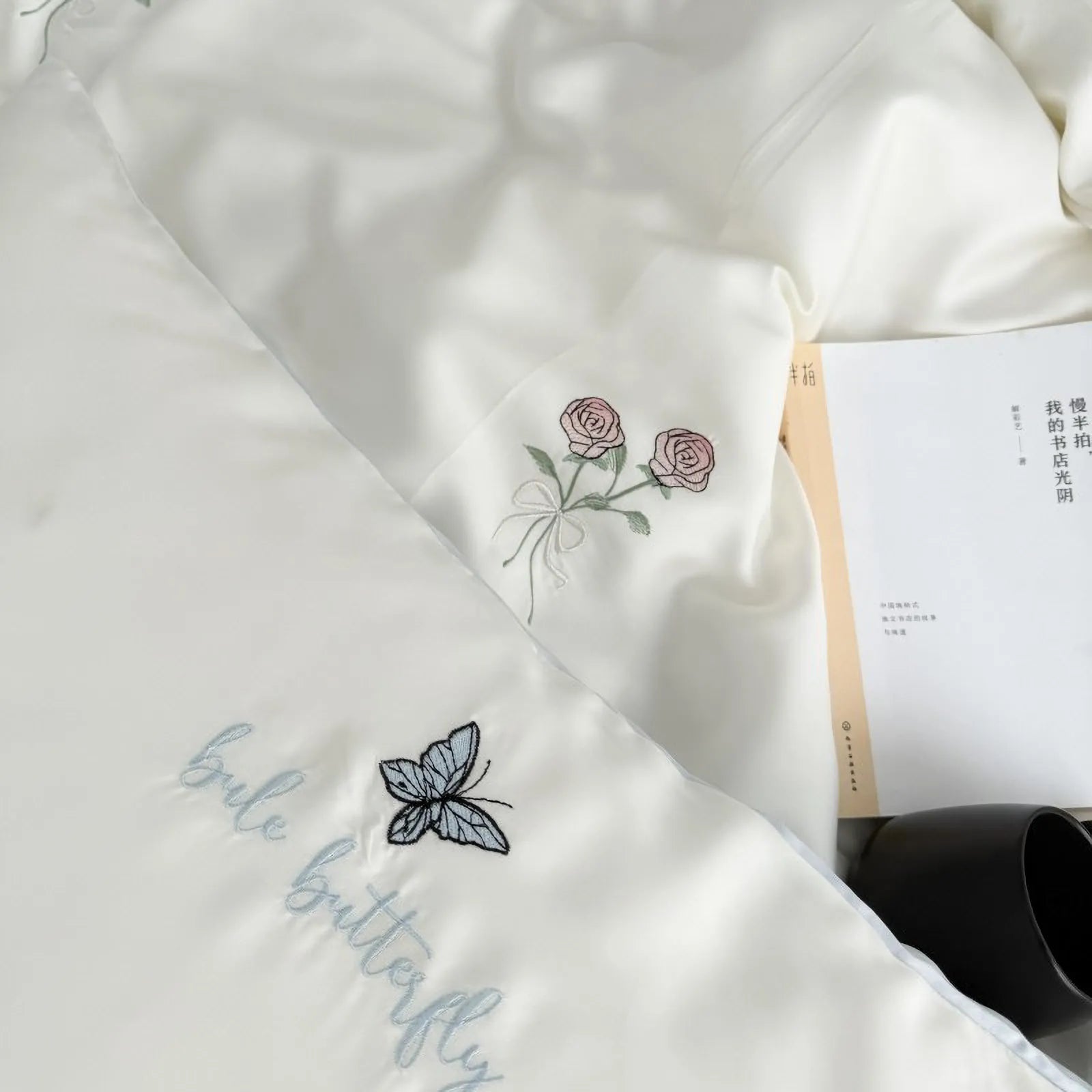 A close-up view of the Cream White duvet cover and pillowcase, highlighting the intricate rose and butterfly embroidery.
