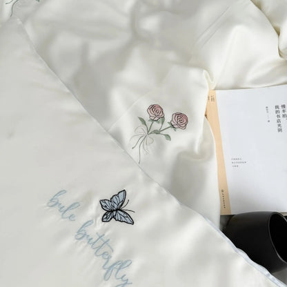 A close-up view of the Cream White duvet cover and pillowcase, highlighting the intricate rose and butterfly embroidery.