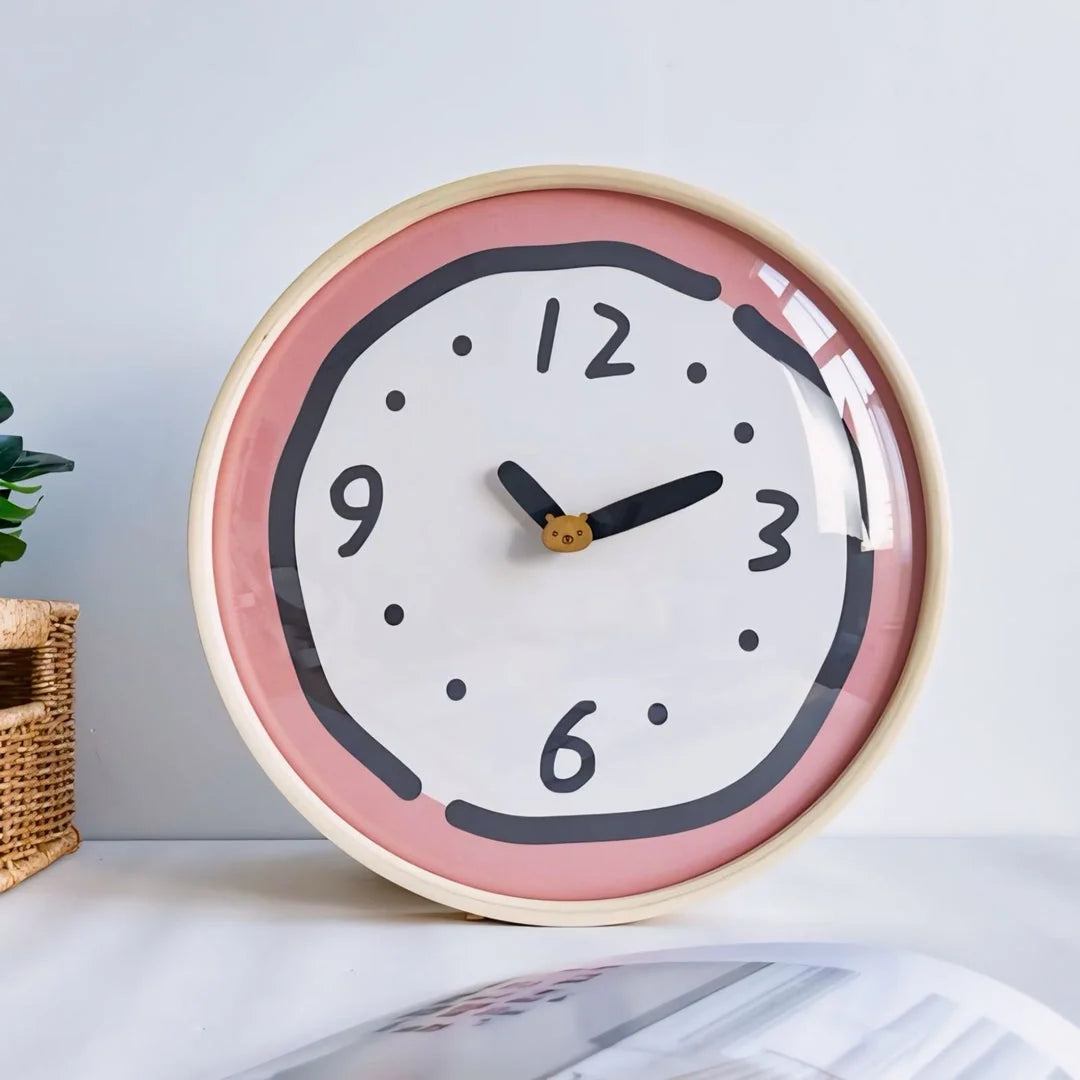 Close-up of the Pink Doodle Wall Clock sitting on a desk - RoomDen.