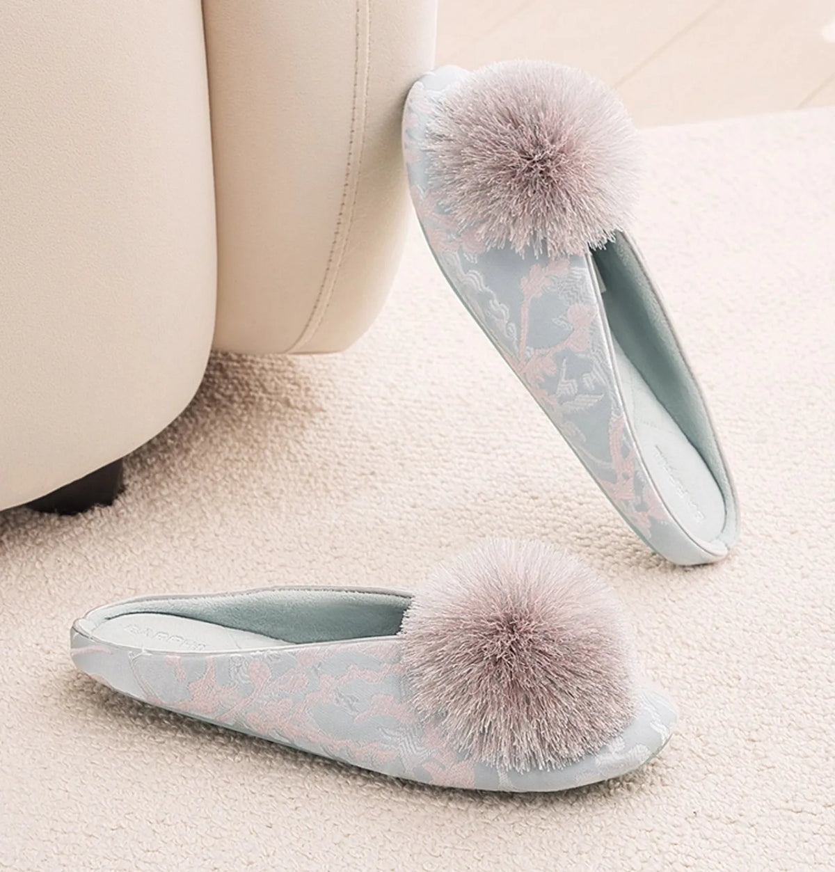 Top down view of blue floral jacquard slippers on carpet - RoomDen