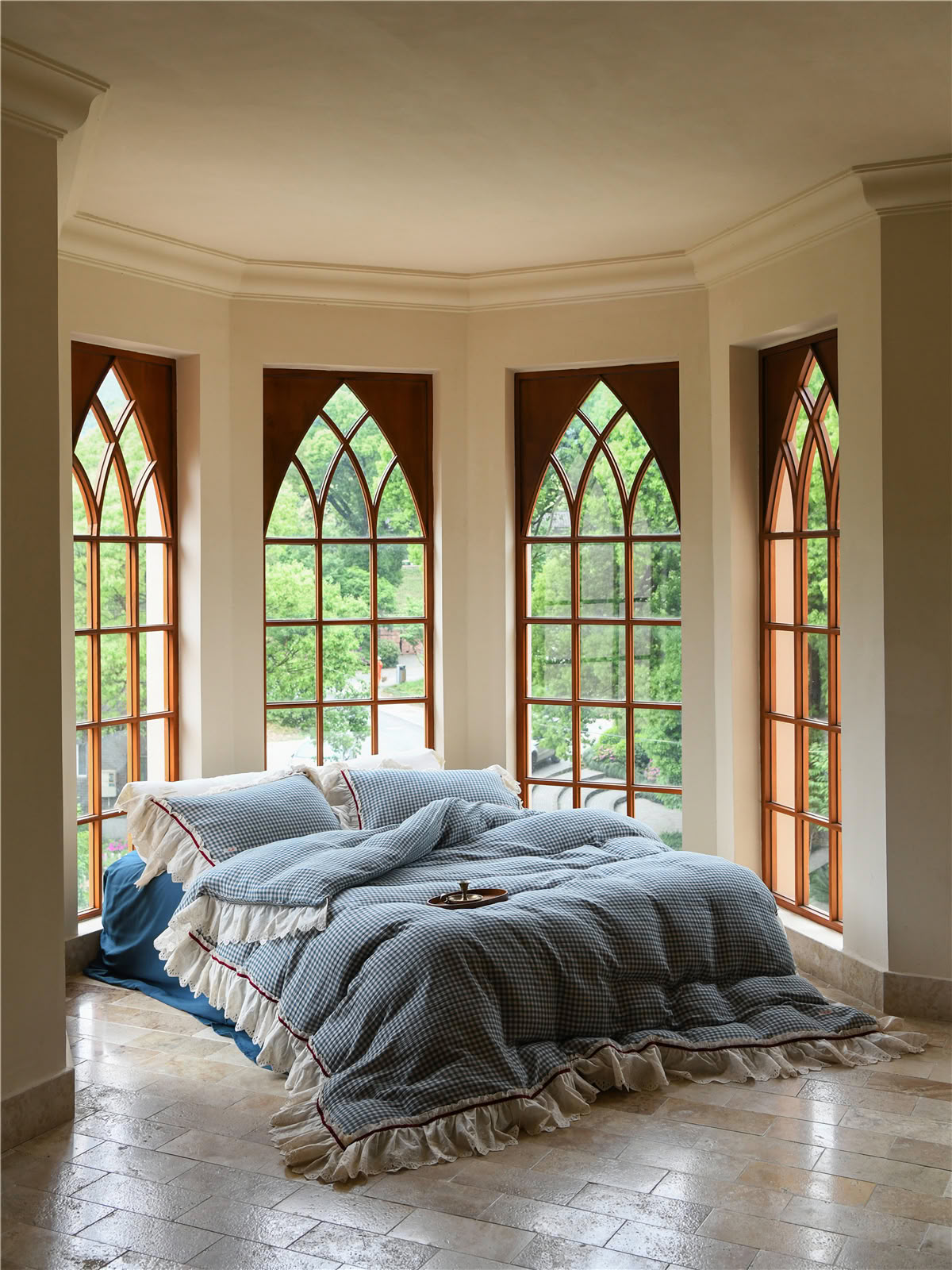 Blue gingham ruffled bedding set with lace trim in a bright bay window room - RoomDen