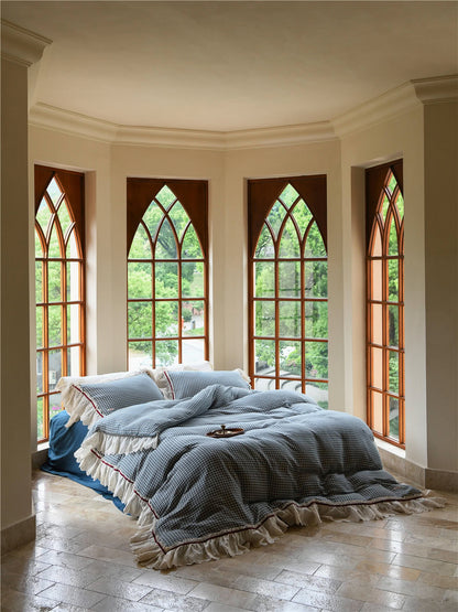 Blue gingham ruffled bedding set with lace trim in a bright bay window room - RoomDen