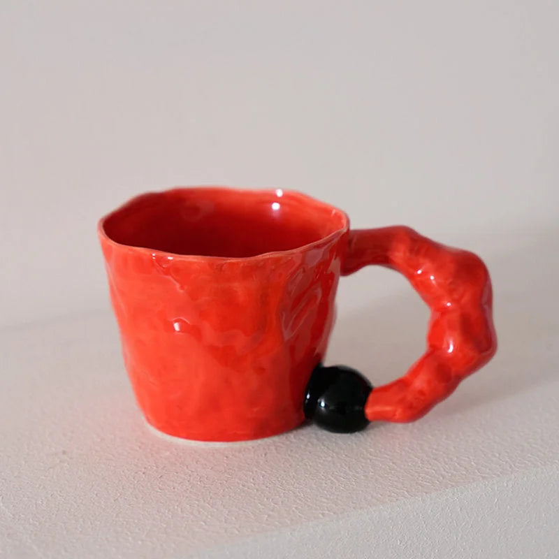 Front view of the red textured ceramic mug with a black accent on its chunky handle - RoomDen.