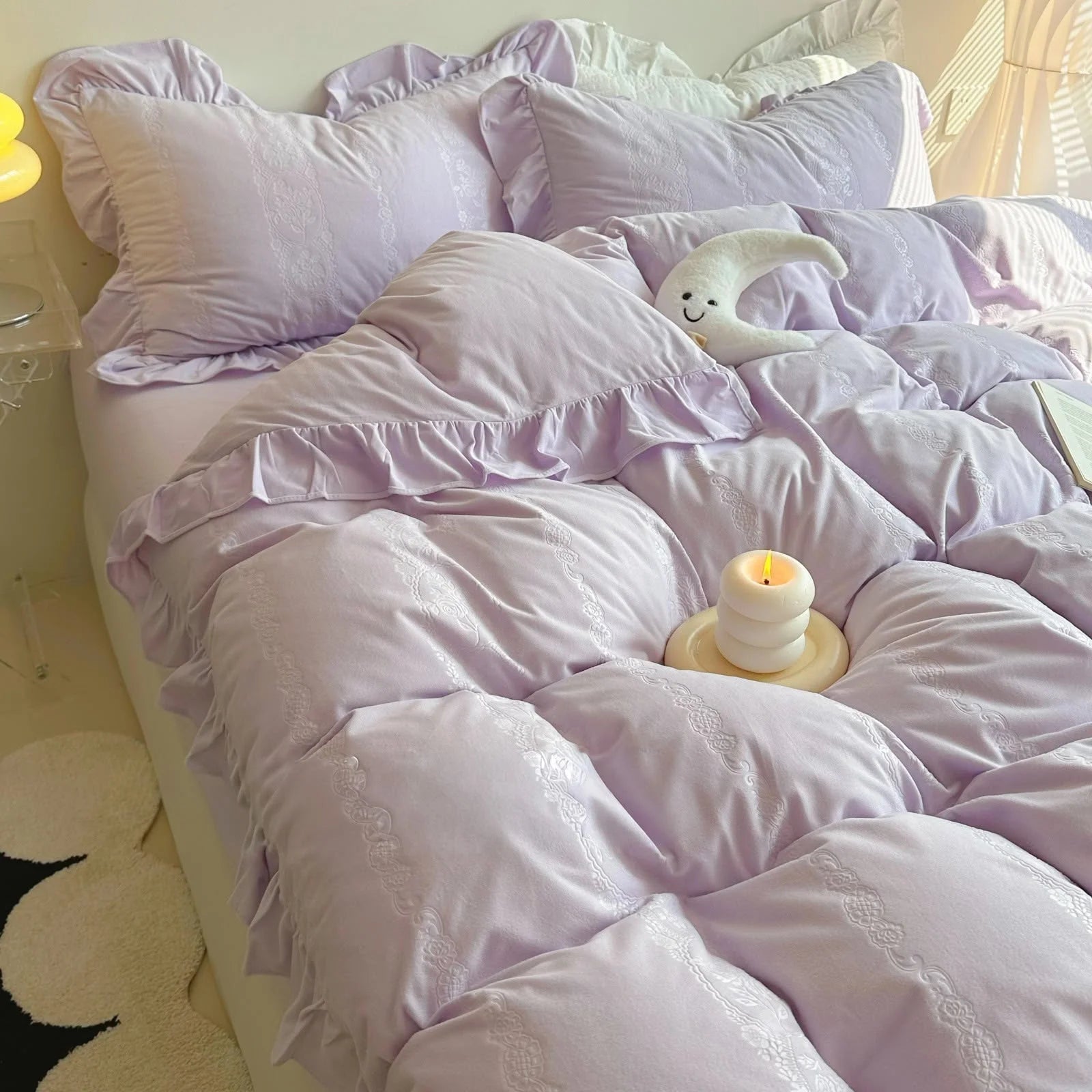 Plush Ruffled Jacquard Velvet Bedding Set in Lavender, styled with a candle and moon plushie. - RoomDen