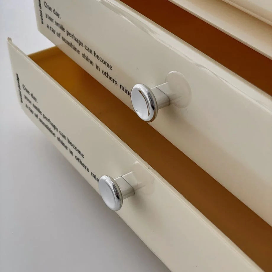 Macro shot of the silver-tone knobs on the drawers of the cream makeup organizer.