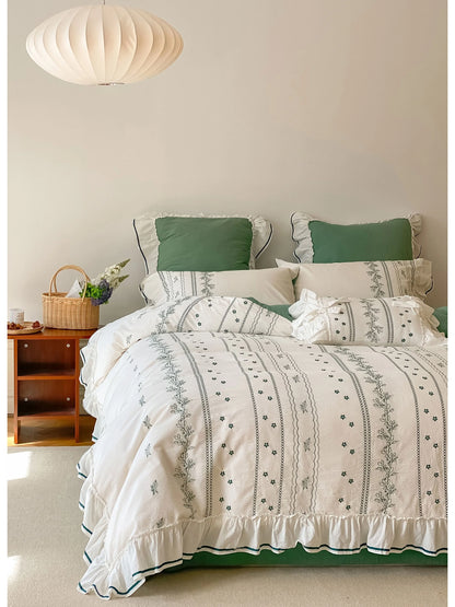 Ruffled Floral Vine Embroidered Cotton Bedding Set in Forest Green, shown on a bed with a modern pendant light. - RoomDen