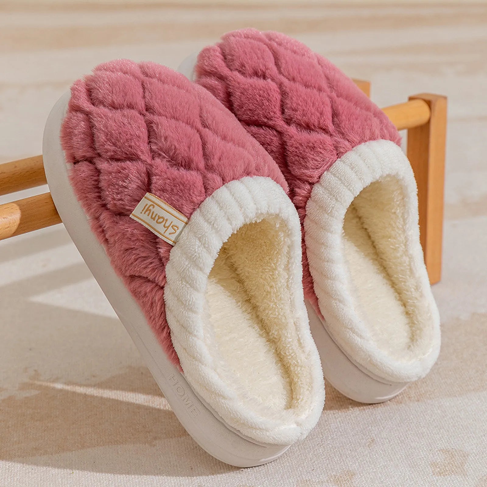 Pair of Dusty Pink quilted cotton slippers leaning on a wooden rack - RoomDen