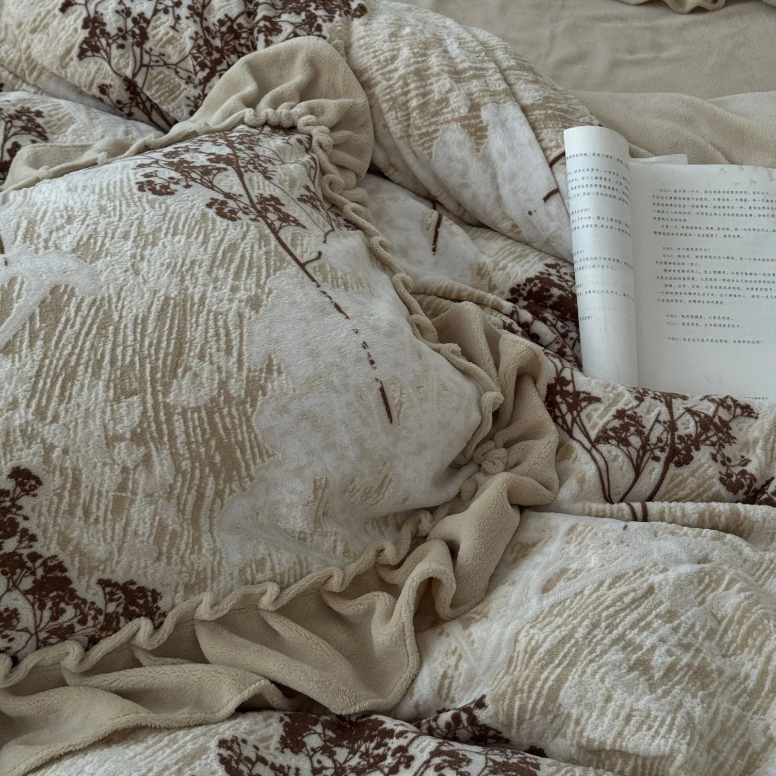 Close-up detail of the textured fabric and ruffle trim on the pillowcase of the floral branch washed cotton bedding set.