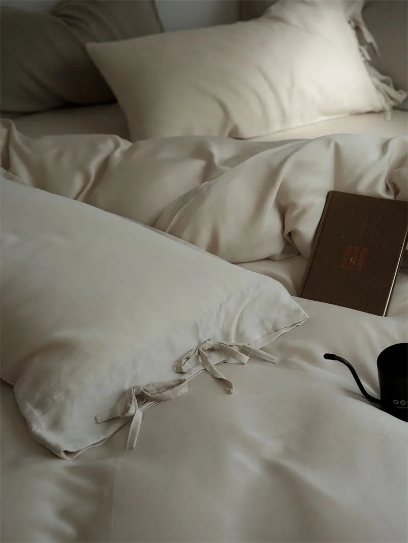 Close-up of the tie closure detail on the Oatmeal Beige Tencel pillowcase next to a book - RoomDen