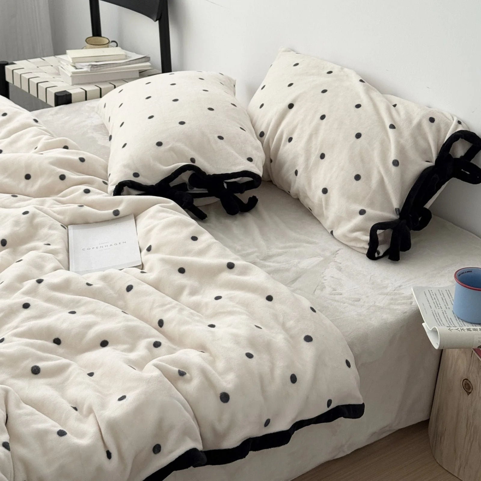 Creamy White Polka Dot Flannel Fleece Bedding Set with a book, styled in a bright, modern bedroom.