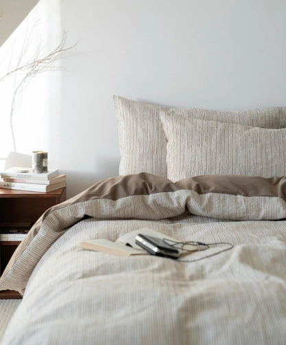 Full view of the Latte Brown pinstripe bedding set in a serene bedroom setting with natural light - RoomDen