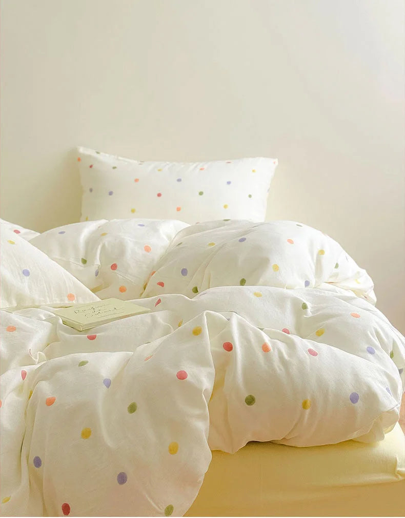 A cozy, slightly messy bed with the Colorful Polka Dot Washed Cotton Bedding Set - RoomDen