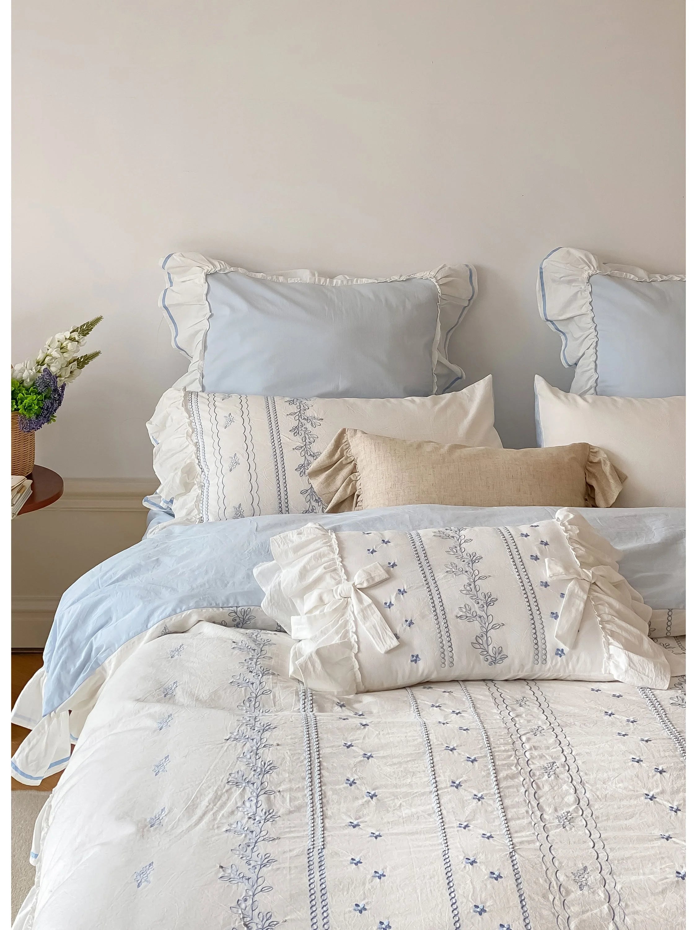 Styled view of the Cornflower Blue embroidered bedding set, showcasing the ruffled pillow shams.