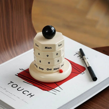 The vintage-style wooden perpetual calendar sitting on a "TOUCH" art book. - RoomDen