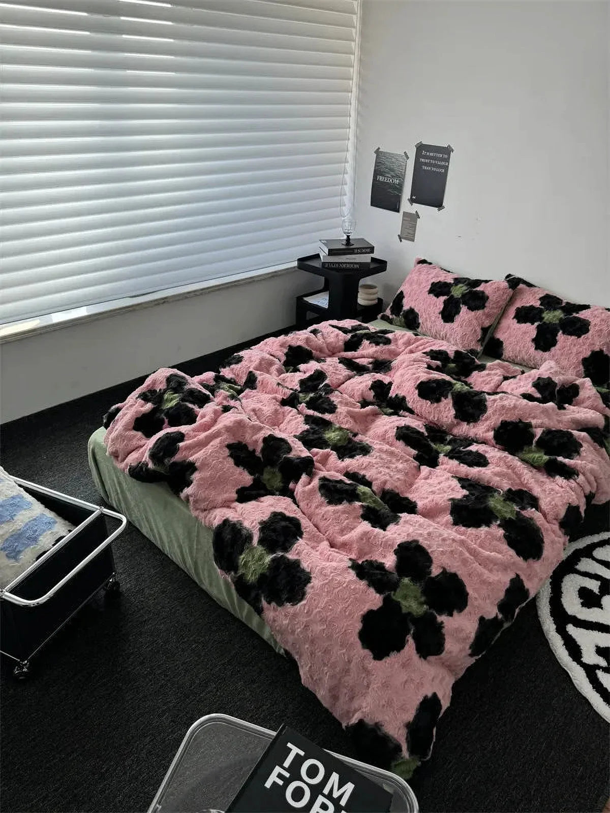 Angled view of the pink and black abstract floral fleece bedding set in a bright, modern bedroom with white blinds. - RoomDen