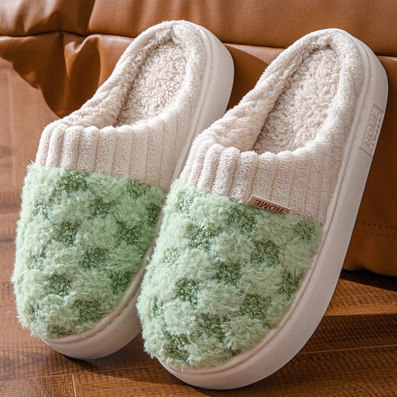 Close up of green and white checkered plush slippers leaning on sofa - RoomDen