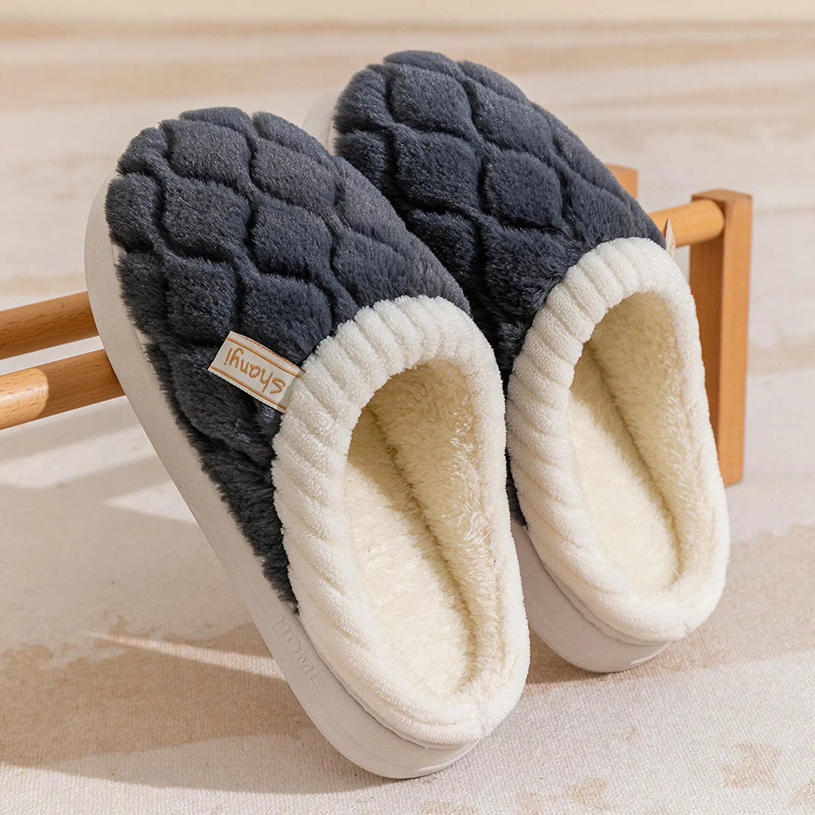 Pair of Charcoal Grey diamond quilted slippers on a wooden rack - RoomDen