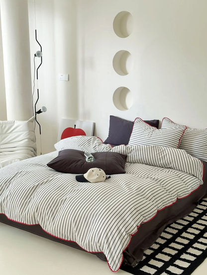 Close up of Black Striped Pillowcase with Red Embroidery Detail - RoomDen
