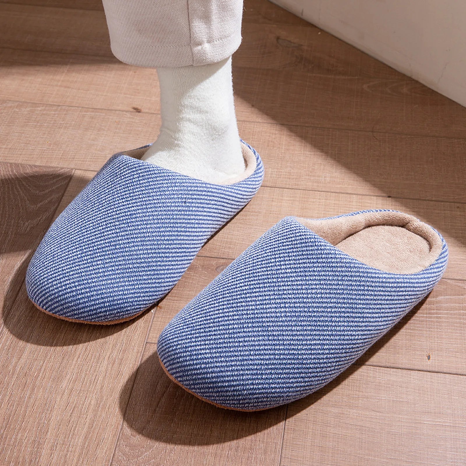 Blue cotton slippers on feet walking on wood floor roomden