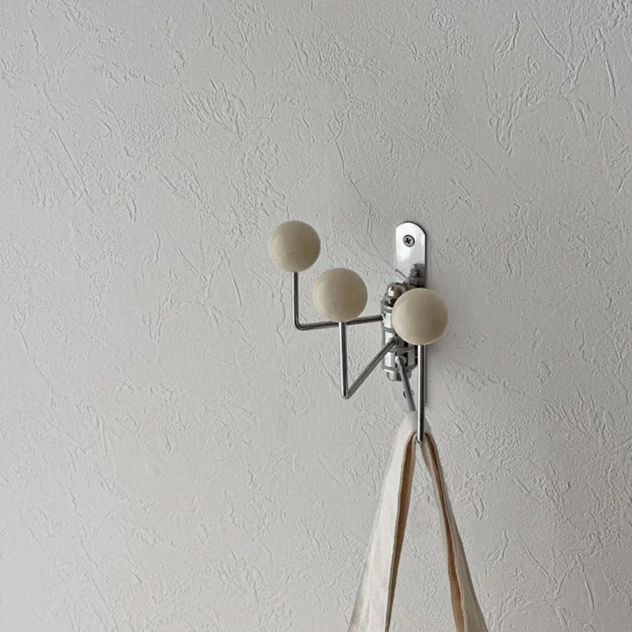 Angled view of the cream triple-arm swivel hook, highlighting its minimalist design - RoomDen.