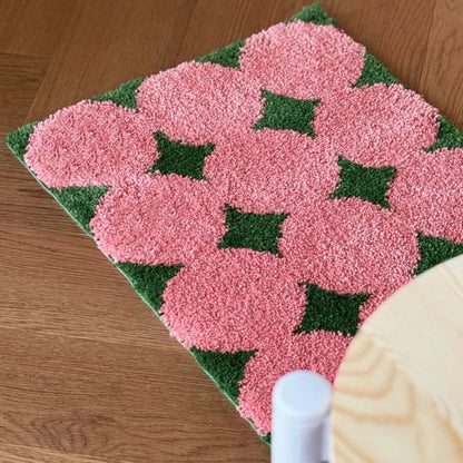 Top down view of pink flower field pattern rug on floor - RoomDen