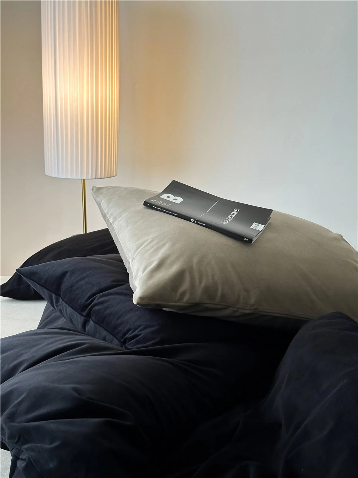 Close-up shot of the plush texture of the Obsidian Black and cream velvet pillowcases. - RoomDen