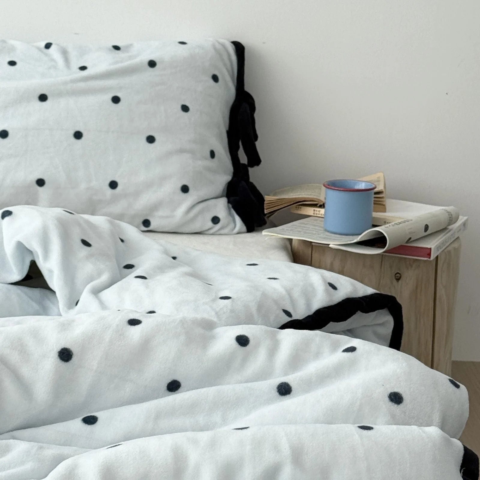 Light Blue Polka Dot Flannel Fleece Bedding next to a wooden nightstand with a blue mug.