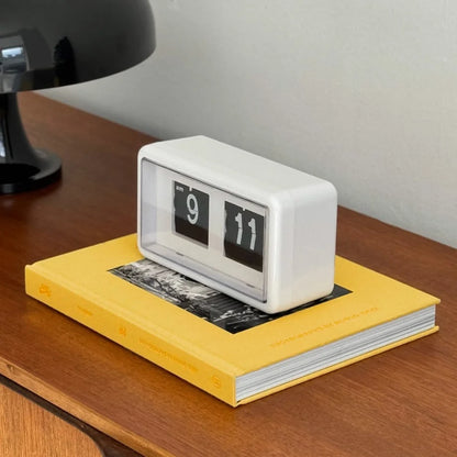 Angled view of the white minimalist flip clock, showing its clean lines and transparent cover. - RoomDen