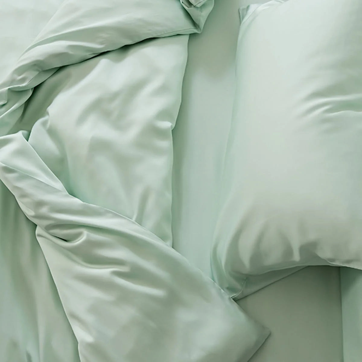 Top-down detail shot of the rumpled Mint Green Tencel duvet cover, showing its softness.