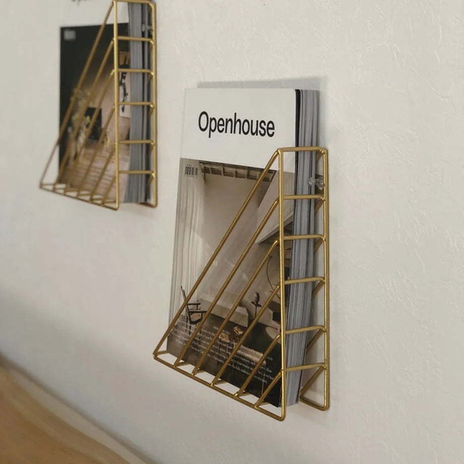 Side view showing multiple magazines stored neatly in the gold wall organizer - RoomDen