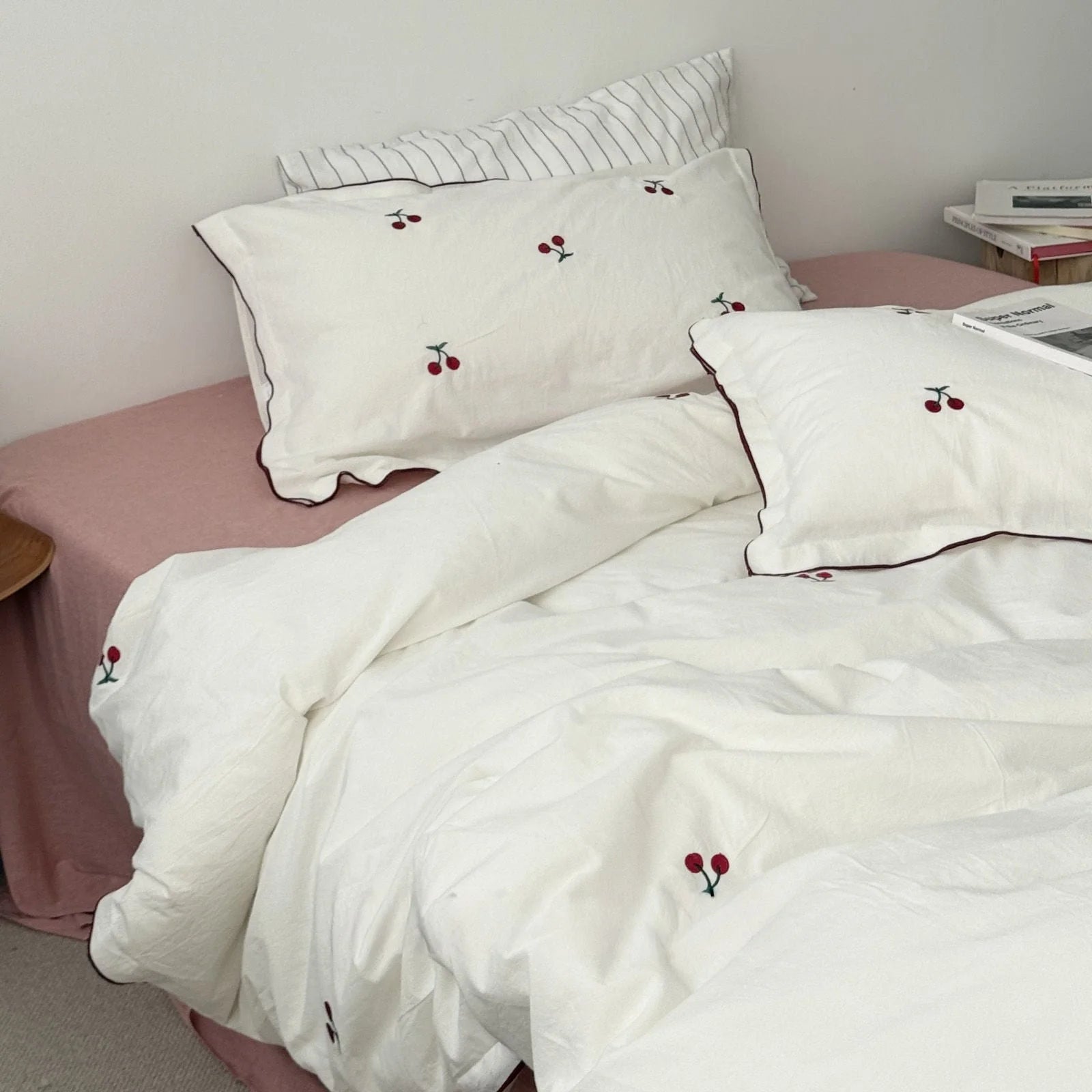 Pure white cherry embroidered duvet cover and pillowcases arranged on a cozy bed.