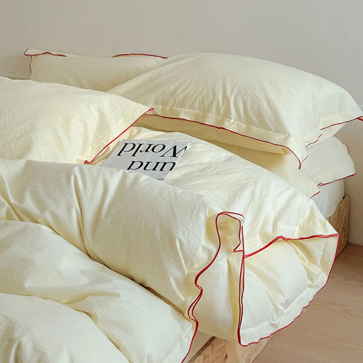 Another angle of the buttercream washed cotton bedding set, highlighting the delicate red ruffle edge on the pillowcases.