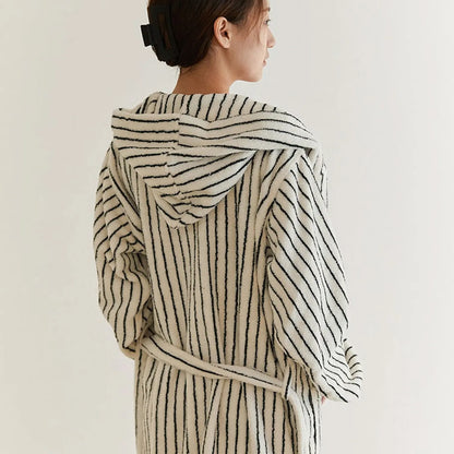 Back view of a woman wearing the hooded striped robe, highlighting the hood design and vertical lines.