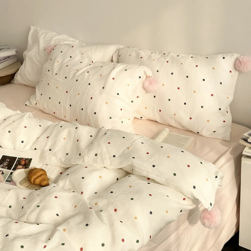 Full view of the white and colorful polka dot washed cotton bedding set with pink pom-poms. - RoomDen