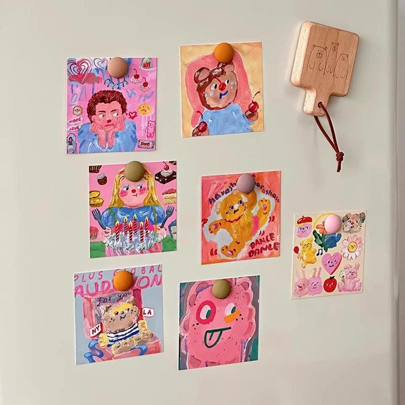 A smaller arrangement of the cute cartoon art prints on a fridge, showing their versatility as decor magnets - RoomDen.